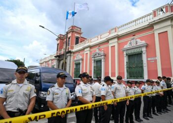 Police officers remain outside the headquarters of the Supreme Electoral Tribunal while prosecutors from the Public Ministry carry out a raid in Guatemala City on September 29,2023. Guatemalas electoral court was raided on Friday by the questioned prosecutors office to request information on the minutes of the electoral process that led to the presidency of the Social Democrat, Bernardo Arévalo, official sources reported. (Photo by Johan ORDONEZ / AFP)