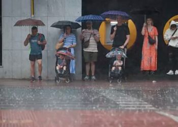Un grupo de personas se protege de la lluvia en Valencia.Juan Carlos CárdenasEFE
