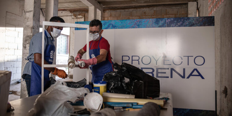 AME1110. MARACAIBO (VENEZUELA), 20/09/2023.- Integrantes del Proyecto Sirena arman alfombras y barreras tubulares que permiten "atraer" y "recoger" los restos de petróleo, el 16 de septiembre de 2023, en Maracaibo (Venezuela). El pelo desechado en barberías o peluquerías humanas y caninas del estado Zulia, en el oeste de Venezuela, ahora es recogido por los voluntarios del Proyecto Sirena, una iniciativa que plantea crear artilugios a base de cabello para limpiar los residuos de petróleo que contaminan el lago de Maracaibo, el más grande del país. EFE/ Henry Chirinos
