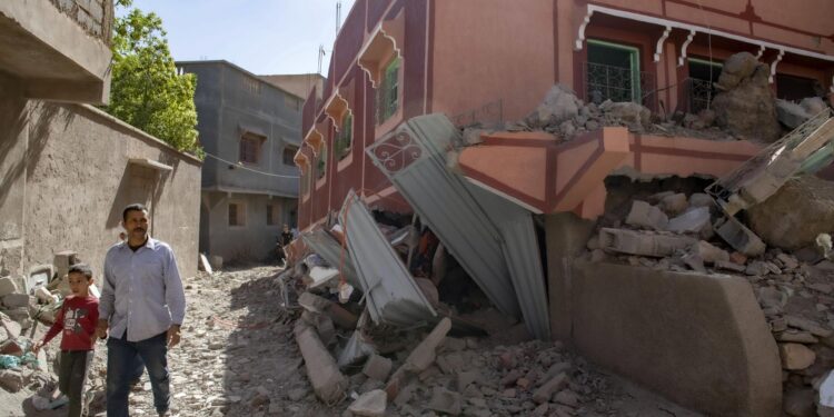 Marrakesh (Morocco), 09/09/2023.- A person with a child walk next to a damaged building following an earthquake in Marrakesh, Morocco, 09 September 2023. A powerful earthquake that hit central Morocco late 08 September, killed at least 820 people and injured 672 others, according to a provisional report from the country's Interior Ministry. The earthquake, measuring magnitude 6.8 according to the USGS, damaged buildings from villages and towns in the Atlas Mountains to Marrakesh. (Terremoto/sismo, Marruecos) EFE/EPA/JALAL MORCHIDI