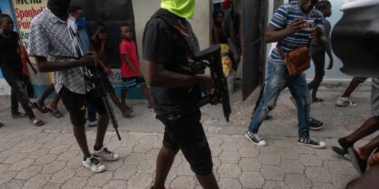 AME1029. PUERTO PRINCIPE (HAITÍ), 19/09/2023.- Miembros de grupos armados son vistos vigilando las calles, hoy en Puerto Príncipe (Haití). El jefe de la poderosa banda armada haitiana G9 Jimmy Cherisier, alias Barbecue, encabezó este martes en Puerto Príncipe una manifestación a la que asistieron varios centenares de personas y en la que se pedía la salida del poder del primer ministro, Ariel Henry. Escoltado por varios hombres encapuchados y visiblemente armados, Barbecue exigió la dimisión de Henry, al que calificó de "incapaz" de seguir al frente del país. EFE/ Johnson Sabin