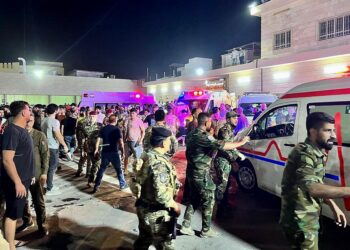 Soldiers and emergency responders gather around ambulances carrying wounded people after a fire broke out during a wedding at an event hall, outside the Hamdaniyah general hospital in Al-Hamdaniyah, Iraq on September 27, 2023. At least 100 people were killed and more than 150 injured when a fire broke out during a wedding at an event hall in the northern Iraqi town of Al-Hamdaniyah, according to state media and health officials, on September 27, 2023. (Photo by Zaid AL-OBEIDI / AFP)
