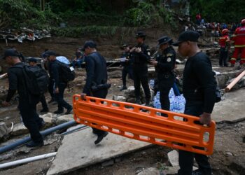 Police officers work at the site where a sewage-polluted river swollen by heavy rains swept away precarious homes at Dios es Fiel shantytown, in the Kjell Laugerud colony in Guatemala City, taken on September 25, 2023. At least six people were killed and 13 others are missing after a river overflowed due to heavy rains, sweeping away six homes in the center of Guatemala's capital. (Photo by Johan ORDONEZ / AFP)