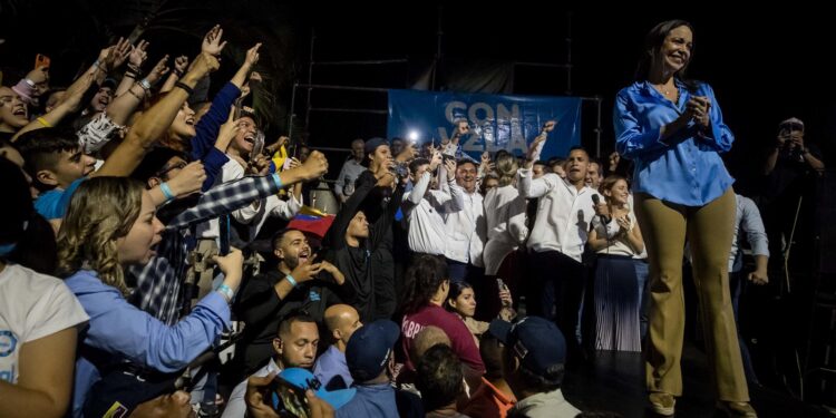 CARACAS (VENEZUELA) 23/10/2023 - La exdiputada Maria Corina Machado (d) sonríe mientras celebra junto a aliados y seguidores en las primeras horas de este lunes los resultados ofrecidos por la comisión de elecciones primarias, en Caracas (Venezuela). La exdiputada María Corina Machado es la gran triunfadora de las primarias opositoras de este domingo en Venezuela, con el 93,13 % de los votos, con un 26,06 % de las actas escrutadas, de unas votaciones en las que los venezolanos eligieron a quien debe enfrentarse al chavismo en las presidenciales de 2024. EFE/ Miguel Gutiérrez