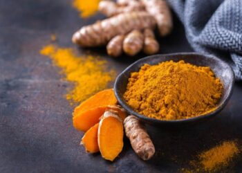 Food and drink, diet nutrition, health care concept. Raw organic orange turmeric root and powder, curcuma longa on a cooking table. Indian oriental low cholesterol spices. Copy space background