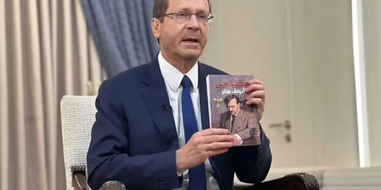 El presidente Isaac Herzog sostiene una copia de una traducción al árabe de "Mein Kampf" encontrada por las tropas israelíes en una base terrorista en la Franja de Gaza (Presidencia de Israel)