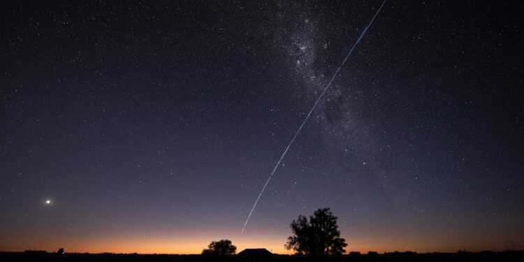 This long-exposure image shows a trail of a group of SpaceX's Starlink G6-27 satellites passing over Uruguay, with part of the Milky Way and planet Venus (L) in the frame, as seen from the countryside some 185 km north of Montevideo near Capilla del Sauce, Florida Department, at twilight early on November 12, 2023. (Photo by Mariana SUAREZ / AFP)