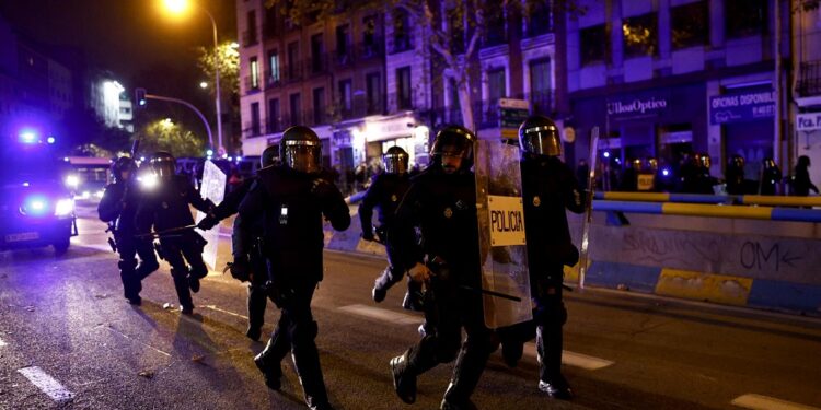 MADRID (ESPAÑA), 11/11/2023.- La Policía ha intervenido la noche de esta sábado para disolver a grupos de manifestantes en la protesta ante la sede nacional del PSOE en la calle Ferraz, en Madrid, después de que algunos encapuchados comenzaran a lanzar objetos contra el cordón policial. EFE/Rodrigo Jiménez