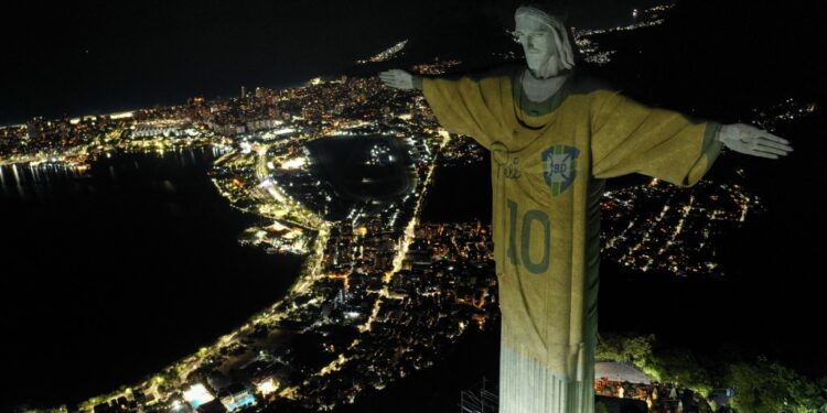 Aerial view showing an image projected onto the Christ the Redeemer statue pays tribute to Brazilian football legend Pele on the first anniversary of his death, at Corcovado Mount in Rio de Janeiro, Brazil, on December 29, 2023. (Photo by Mauro PIMENTEL / AFP)