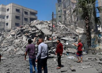 People inspect the rubble of a destroyed residential building that was hit by an Israeli airstrike, in Gaza City, Sunday, May 16, 2021. (AP Photo/Adel Hana)