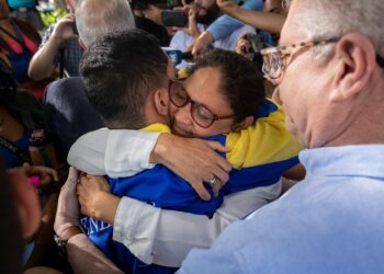 AME6133. CARACAS (VENEZUELA), 23/12/2023.- Wendelin Peña (c) abraza a su hijo, el estudiante universitario John Álvarez, luego de que este saliera en libertad de un centro de reclusión de la Policía Nacional Bolivariana (PNB) hoy, en Caracas (Venezuela). Las autoridades de Venezuela liberaron este sábado a Álvarez, preso desde el pasado 30 de agosto -acusado de conspiración y asociación para delinquir-, tras lo cual fue sometido a "torturas", según organizaciones de derechos humanos. El joven universitario, cuya salida del centro de detención fue corroborada por EFE, se une a la treintena de "presos políticos" que fueron puestos en libertad el pasado jueves, tras lo cual quedan, al menos, 265 personas privadas de la libertad por sus críticas al Ejecutivo, según los registros de varias ONG y de la coalición opositora Plataforma Unitaria Democrática (PUD). EFE/ Rayner Peña R.