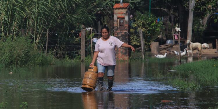 Una mujer camina en medio de una inundación en la comunidad Rancho Chico perteneciente al municipio de Okinawa I en Santa Cruz (Bolivia). EFE/Juan Carlos Torrejón