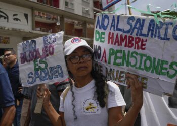 Un maestro lleva carteles durante una protesta docente por mejores salarios y beneficios en Caracas, Venezuela, el lunes 18 de septiembre de 2023. (AP Foto/Ariana Cubillos)
