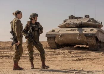 La teniente coronel Or Ben Yehuda, a la derecha, comandante de batallón que dirigió dos compañías en una batalla de 12 horas contra combatientes de Hamas el 7 de octubre de 2023, y otra soldado inspeccionan una zona cerca de Nitzana, en el sur de Israel, el 1 de octubre de 2023 (Avishag Shaar-Yashuv/The New York Times)