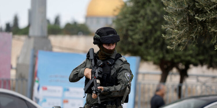 A member of Israeli border police stands guard as Palestinians attend Friday prayers outside the Old City of Jerusalem, October 20, 2023. REUTERS/Ammar Awad