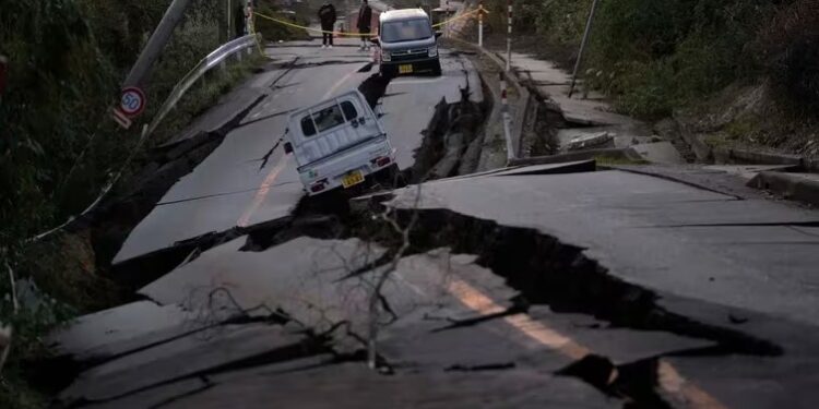 Varios transeúntes observan los daños en una carretera cercana a la ciudad de Noto, en la península de Noto (AP Foto/Hiro Komae)
