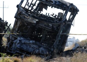 View of a burnt passenger bus after it crashed with a truck at the Mazatlan-Culiacan highwat in the community of La Cruz, Sinaloa state, Mexico on January 30, 2024. A crash between a passenger bus and a trailer left several dead and injured on Tuesday in the Mexican state of Sinaloa, authorities reported. (Photo by STRINGER / AFP)