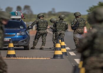 Members of the Brazilian Army check vehicles traveling along BR 174 highway, often used by Venezuelans seeking shelter in Brazil, in Pacaraima, Roraima state, Brazil, on Tuesday, Feb. 20, 2018. Hundreds of thousands of Venezuelans fleeing economic collapse are crowding into cities and makeshift camps in Colombia, Brazil, Ecuador and throughout the region, the largest mass emigration in modern Latin American history. Photographer: Andre Coelho/Bloomberg