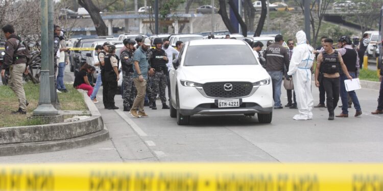 AME533. GUAYAQUIL (ECUADOR), 17/01/2024.- Policías investigan el vehículo con impactos de bala en el que se encontraba el fiscal César Suárez al ser asesinado, hoy en una zona al norte de Guayaquil (Ecuador). El fiscal ecuatoriano que investigaba el asalto de un grupo armado a un canal de televisión en Guayaquil fue asesinado este miércoles a tiros en medio del "conflicto armado interno", decretado por el Gobierno de Ecuador para atajar la espiral de violencia desatada la semana pasada por grupos del crimen organizado. EFE/Jonathan Miranda