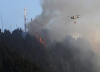 BOG400. BOGOTÁ (COLOMBIA), 24/01/2024.- Un helicóptero combate hoy un incendio forestal en el cerro El Cable, en Bogotá (Colombia). Un nuevo incendio, que ahonda la crisis medioambiental en Colombia, comenzó este miércoles en los cerros orientales de Bogotá, esta vez en uno conocido como El Cable y en donde las autoridades locales tratan de apagar las llamas. EFE/ Carlos Ortega