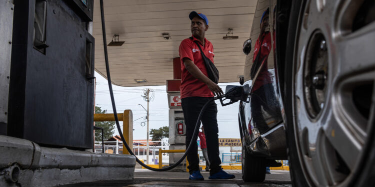 MARACAIBO (VENEZUELA), 07/02/2024.- Un empleado de una estación de servicio despacha combustible hoy, en Maracaibo (Venezuela). El contrabando y la reventa interna de la gasolina en Venezuela persisten, según expertos, más de tres años después de que el Gobierno aumentara su precio, lo que puso fin a un subsidio total que se hizo "insostenible", pues el combustible pasó un quinquenio prácticamente regalado. EFE/ Henry Chirinos
