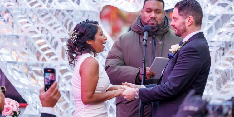 New York (United States), 14/02/2024.- Kathy Gualotuna says her wedding vows to Peter Ruggles as they get married near American artist Lovie Pignata's 'Smitten' ice sculpture, on Valentine's Day in Times Square, New York, New York, USA, 14 February 2024. A large-scale version of Lovie Pignata's 'Smitten' ice sculpture was installed in Times Square for the annual 'Love in Times Square' celebration on Valentine's Day. (Nueva York) EFE/EPA/SARAH YENESEL