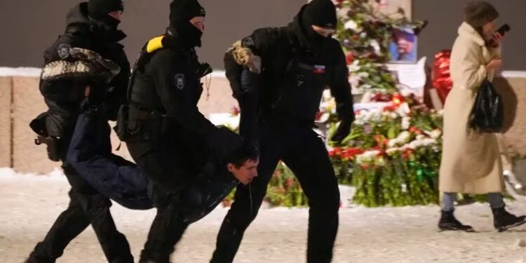 Agentes de policía detienen a un hombre que depositaba flores para Alexei Navalny en un monumento a las víctimas de la represión política, en San Petersburgo, Rusia, el 16 de febrero de 2024 (AP Foto)