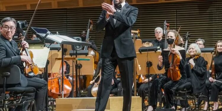 Bradley Cooper saluda a los músicos de la Filarmónica de Nueva York antes del concierto en el Lincoln Center.