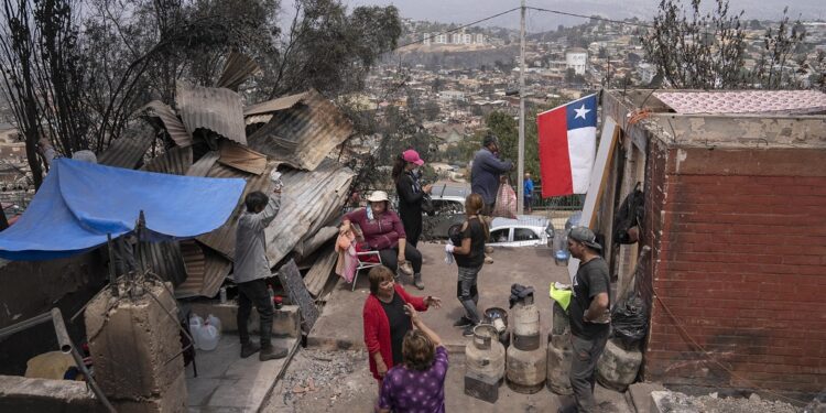 AME5705. VIÑA DEL MAR (CHILE), 04/02/2024.- Personas observan la destrucción de viviendas, hoy en el sector de Achupallas, afectado por incendios forestales de Viña del Mar, Región de Valparaiso (Chile). El número de fallecidos en los devastadores incendios que azotan la región de Valparaíso, a 100 kilómetros al oeste de Santiago, aumentó a 99, de los cuales solo 32 han podido ser identificados, informó este domingo el Servicio Médico Legal (SML) de Chile. EFE/ Adriana Thomasa