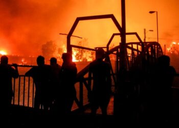 Un grupo de vecinos observa mientras las llamas devoran un edificio en Viña del Mar. (AP/Cristobal Basaure)AP