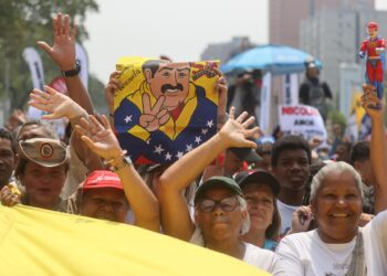 AME2269. CARACAS (VENEZUELA), 25/03/2024.- Simpatizantes del oficialismo se reúnen este lunes para mostrar su apoyo y acompañar a su candidato a las próximas elecciones del 28 de julio, el actual mandatario Nicolás Maduro, a oficializar su aspiración ante el Consejo Nacional Electoral (CNE), en Caracas (Venezuela). El proceso de presentación de candidaturas para las presidenciales concluye este lunes, con la inscripción de Maduro, mientras que la oposición mayoritaria espera poder postular a Corina Yoris, su aspirante ante la inhabilitación de María Corina Machado, ganadora de las primarias de octubre. EFE/ Miguel Gutiérrez