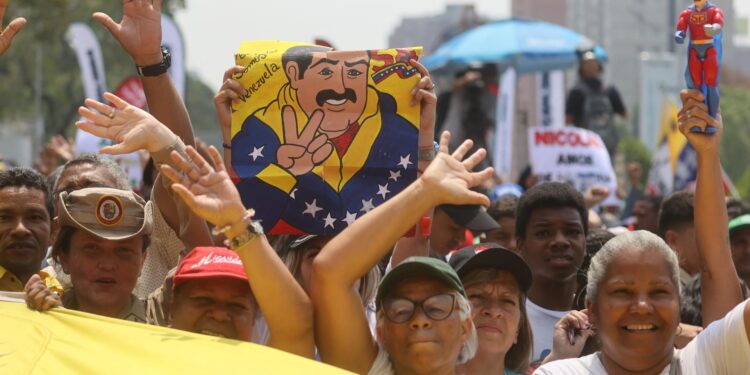 AME2269. CARACAS (VENEZUELA), 25/03/2024.- Simpatizantes del oficialismo se reúnen este lunes para mostrar su apoyo y acompañar a su candidato a las próximas elecciones del 28 de julio, el actual mandatario Nicolás Maduro, a oficializar su aspiración ante el Consejo Nacional Electoral (CNE), en Caracas (Venezuela). El proceso de presentación de candidaturas para las presidenciales concluye este lunes, con la inscripción de Maduro, mientras que la oposición mayoritaria espera poder postular a Corina Yoris, su aspirante ante la inhabilitación de María Corina Machado, ganadora de las primarias de octubre. EFE/ Miguel Gutiérrez