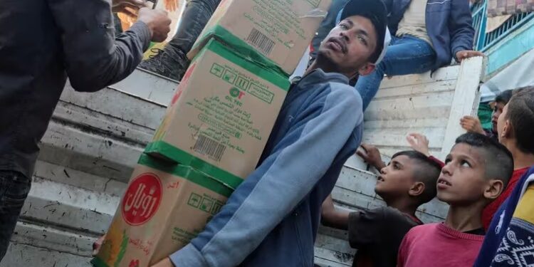 FILE PHOTO Palestinians distribute aid amid the ongoing conflict between Israel and Hamas, at a shelter center in Deir Al-Balah, in the central Gaza Strip April 7, 2024. REUTERSRamadan AbedFile Photo.