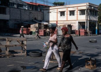 PUERTO PRÍNCIPE (HAITÍ), 02/04/2024.- Mujeres caminan por Champs Mars, la principal plaza pública de la ciudad, este martes en Puerto Príncipe (Haití). Al menos cinco policías resultaron heridos, uno de ellos de gravedad, después del intento fallido de una poderosa banda armada haitiana de asaltar este lunes el Palacio Nacional en Puerto Príncipe. EFE/ Johnson Sabin