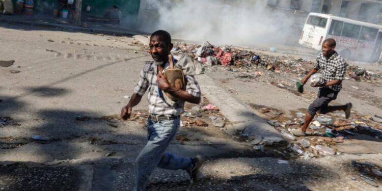 Hombres corren a refugiarse mientras la policía antidisturbios lanza gases lacrimógenos en un esfuerzo por dispersar a la gente cerca del Palacio Nacional, en Puerto Príncipe, Haití, el martes 2 de abril de 2024. [Foto: Archivo/AP].