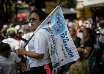 AME1938. CARACAS (VENEZUELA), 01/05/2024.-Una mujer sostiene un letrero durante una manifestación en conmemoración del Día Internacional del Trabajo este miércoles, en Caracas (Venezuela). Sindicatos y trabajadores de Venezuela salen a las calles a protestar para exigir un incremento de sus salarios y mejoras en los beneficios laborales. EFE/ Miguel Gutiérrez