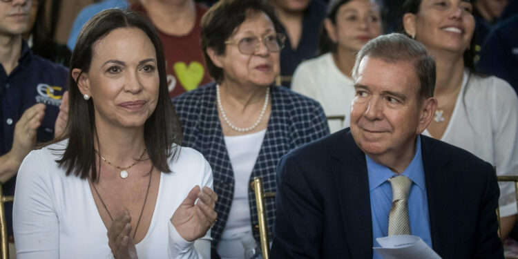 AME6389. CARACAS (VENEZUELA), 16/05/2024.- La líder opositora María Corina Machado (i) aplaude junto al candidato presidencial Edmundo González Urrutia (d) este jueves en Caracas (Venezuela). El candidato presidencial de la principal coalición opositora de Venezuela -la Plataforma Unitaria Democrática (PUD)-, Edmundo González Urrutia, aseguró este jueves que, si gana las elecciones del próximo 28 de julio, su compromiso es lograr la reconciliación de los venezolanos. EFE/ Miguel Gutierrez