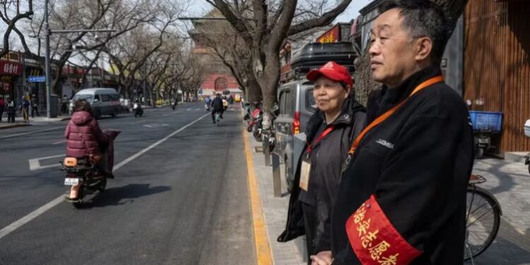 Voluntarios de un comité vecinal vigilando una calle de Beijing; el “mantenimiento de la estabilidad”, un término general para contener los problemas sociales y silenciar la disidencia, se ha convertido cada vez más en una preocupación en China bajo el gobierno de Xi Jinping (Gilles Sabrié/The New York Times)