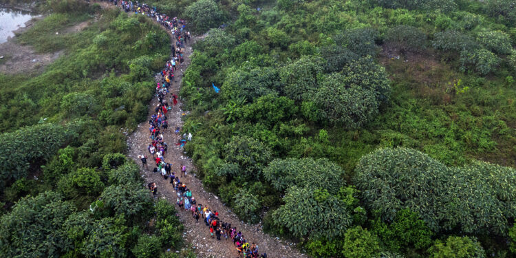 Aerial view of Migrants walking by the jungle near Bajo Chiquito village, the first border control of the Darien Province in Panama, on September 22, 2023. The clandestine journey through the Darien Gap usually lasts five or six days, at the mercy of all kinds of bad weather. More than 390,000 migrants have entered Panama through this jungle so far this year, far more than in all of 2022, when there were 248,000, according to official Panamanian data. (Photo by Luis ACOSTA / AFP)