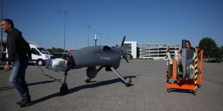 Un hombre tira de un carro con piezas de un dron Leonard en el exterior de un pabellón de la 30ª Exposición Internacional de la Industria de Defensa en Kielce, Polonia (REUTERS/Kacper Pempel)