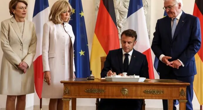 El presidente francés Emmanuel Macron firma en el libro de visitas mientras su esposa Brigitte Macron, el presidente alemán Frank-Walter Steinmeier y su esposa Elke Budenbender observan en Berlín (REUTERS/Liesa Johannssen)