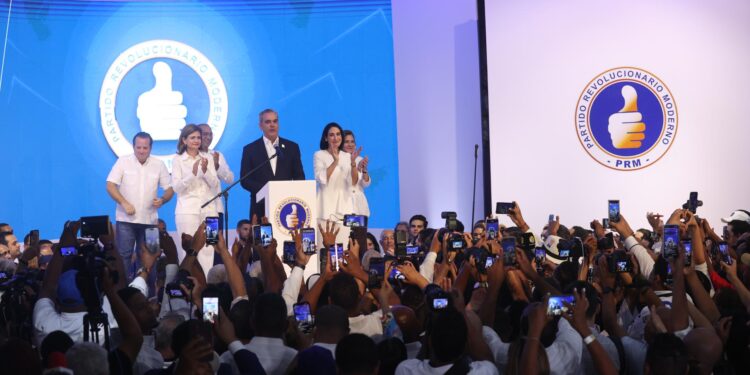 AME7414. SANTO DOMINGO (REPÚBLICA DOMINICANA), 19/05/2024.- El actual presidente de República Dominicana, Luis Abinader acompañado de la primera dama Raquel Arbaje (d), habla a sus seguidores este domingo en Santo Domingo (República Dominicana). El actual presidente de República Dominicana, Luis Abinader, fue reelegido este domingo en primera vuelta, con el 59,11 % de los votos, más del doble de los obtenidos por el candidato situado en segunda posición, el ex jefe de Estado Leonel Fernández, con el 20,67 % de los votos escrutados. EFE/Orlando Barría