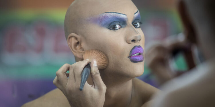 AME7550. CARACAS (VENEZUELA), 28/06/2024.- Aisak Ovalles se maquilla momentos antes de la presentación de un espectáculo el 21 de junio del 2024 en Caracas (Venezuela).Con maquillaje, vestuarios luminosos, pelucas y tacones, una 'drag queen' en Venezuela realiza en el escenario no solo una presentación artística, sino también una protesta, según personas vinculadas con este movimiento, que insiste en seguir desarrollándose a pesar de los prejuicios arraigados en la sociedad del país caribeño. EFE/ Miguel Gutierrez