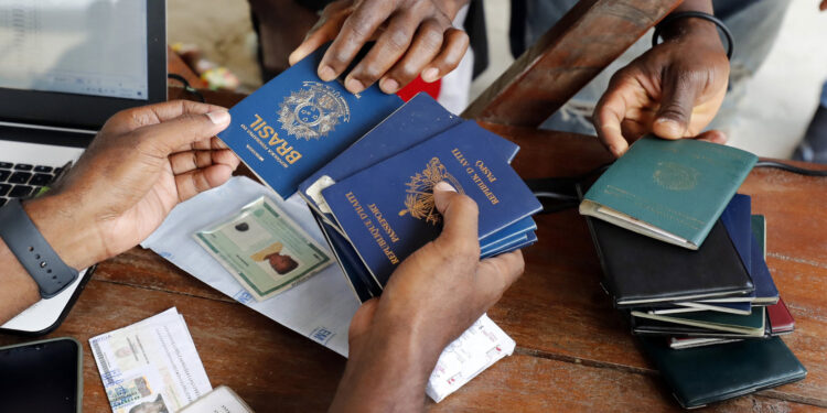 AME5069. NECOCLÍ (COLOMBIA), 19/06/2024.- Fotografía de archivo fechada el 3 de mayo de 2021 de una persona mientras recibe pasaportes de migrantes de diversas partes del mundo que compran tiquetes para Capurganá, en el embarcadero de Necoclí (Colombia). En América Latina y el Caribe hay 23 millones de personas refugiadas, desplazadas internas o apátridas como consecuencia de seis grandes crisis humanitarias que ponen a la región en una emergencia sin precedentes, según cifras divulgadas por ACNUR en vísperas del Día Mundial del Refugiado. EFE/ Mauricio Duenas Castañeda ARCHIVO