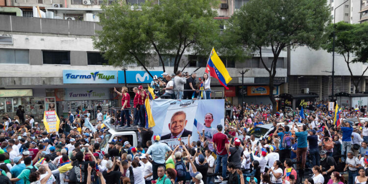 AME9387. CARACAS (VENEZUELA), 04/07/2024.- La líder opositora María Corina Machado (d) saluda durante un acto de campaña del Candidato opositor Edmundo González Urrutia (c) este jueves, en Caracas (Venezuela). González Urrutia prometió en el cierre de la primera jornada de la campaña electoral, "salarios dignos para todos" los trabajadores del país, donde el sueldo mínimo equivale hoy a unos 3,5 dólares al mes. EFE/ Ronald Peña R.