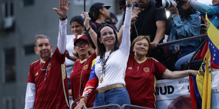 AME9387. CARACAS (VENEZUELA), 04/07/2024.- La líder opositora María Corina Machado (d) saluda durante un acto de campaña del Candidato opositor Edmundo González (i) este jueves, en Caracas (Venezuela). Comienza oficialmente la campaña electoral para las presidenciales del 28 de julio, en las que se medirán diez candidatos, entre ellos el actual presidente, Nicolás Maduro, y el abanderado de la mayor coalición opositora -la Plataforma Unitaria Democrática (PUD)-, Edmundo González Urrutia, quienes ya llevan semanas de precampaña con actos proselitistas por diversos estados del país. EFE/ Ronald Peña R.