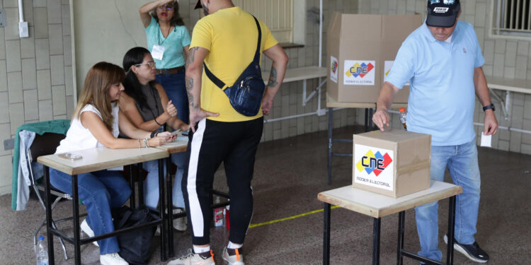 AME5563. CARACAS (VENEZUELA), 28/07/2024.- Un hombre vota este domingo, en un centro de votación en Caracas (Venezuela). Venezuela elegirá presidente en una jornada para la que están llamadas a las urnas más de 21 millones de personas. El Consejo Nacional Electoral (CNE) de Venezuela informó este domingo que, sobre las 08.00 hora local (12.00 GMT), el 95 % de los 15.797 centros de votación ya estaban abiertos -dos horas más tarde la hora oficial fijada para la apertura- y computando los votos de personas que acudieron desde muy temprano a las urnas. EFE/ Ronald Peña R.