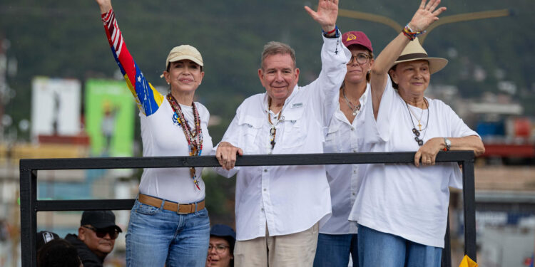 AME1670. VALENCIA (VENEZUELA), 13/07/2024.- La lider de la oposición, María Corina Machado (i) saluda a simpatizantes junto a el candidato presidencial, Edmundo González (c) durante un acto de campaña este sábado en la ciudad de Valencia, estado de Carabobo (Venezuela). La líder opositora de Venezuela María Corina Machado sorteó este sábado "obstáculos" en su viaje hacia Valencia, estado Carabobo, al superar dos cierres de la autopista que conduce hacia esa ciudad, donde encabezará un acto de campaña junto al candidato presidencial Edmundo González Urrutia, de cara a las elecciones del 28 de julio. EFE/ Ronald Peña