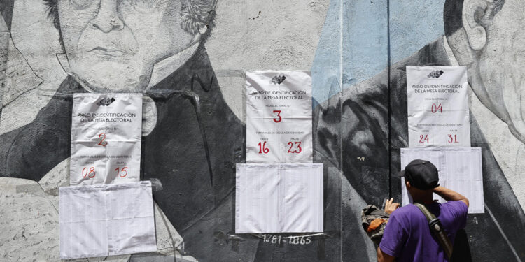 AME5617. CARACAS (VENEZUELA), 28/07/2024.- Un ciudadano venezolano busca su mesa de votación durante la jornada de elecciones presidenciales de Venezuela este domingo, en Caracas (Venezuela). El CNE informó este domingo que, sobre las 08.00 hora local (12.00 GMT), el 95 % de los 15.797 centros de votación ya estaban abiertos -dos horas más tarde la hora oficial fijada para la apertura- y computando los votos de personas que acudieron desde muy temprano a las urnas. EFE/ Henry Chirinos