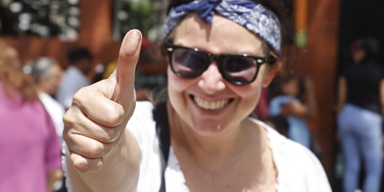 AME5612. CARACAS (VENEZUELA), 28/07/2024.- Una mujer muestra su pulgar luego de votar este domingo, en Caracas (Venezuela). El CNE informó este domingo que, sobre las 08.00 hora local (12.00 GMT), el 95 % de los 15.797 centros de votación ya estaban abiertos -dos horas más tarde la hora oficial fijada para la apertura- y computando los votos de personas que acudieron desde muy temprano a las urnas. EFE/ Henry Chirinos